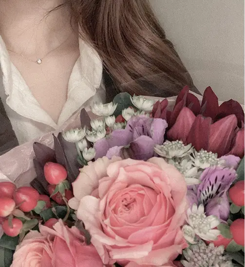 赤とピンクの花束を持った私
